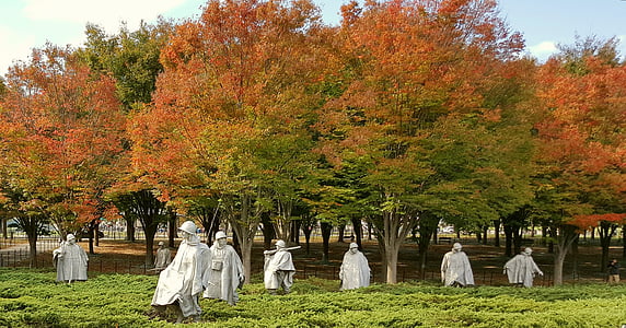 gray statues near red leaf trees thumbnail