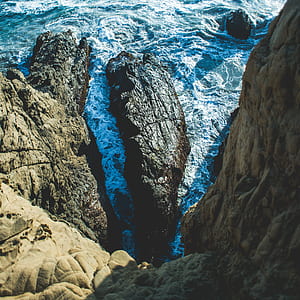 rock formation near body of water during daytime thumbnail