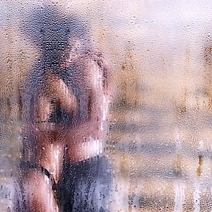 man and woman kissing behind glass window thumbnail
