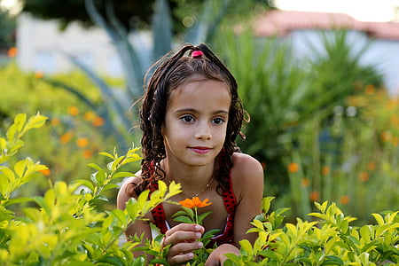 girl holding orange petaled flower thumbnail