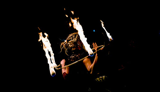silhouette photography of fire dancer with ring of fire thumbnail