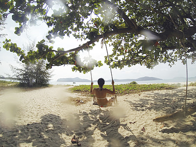 woman using swing on tree branch during daytime thumbnail