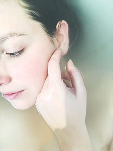 woman on bathtub while holding her ear thumbnail