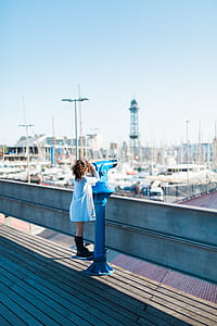 girl standing on blue coin operated telescope thumbnail