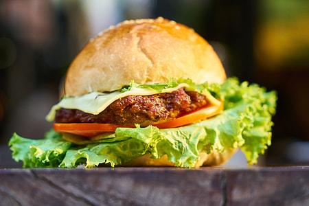 selective focus photography of burger on brown surface thumbnail