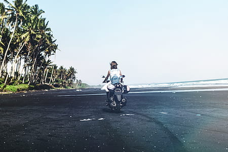 Person Driving Motorcycle Near Green Palm Trees thumbnail