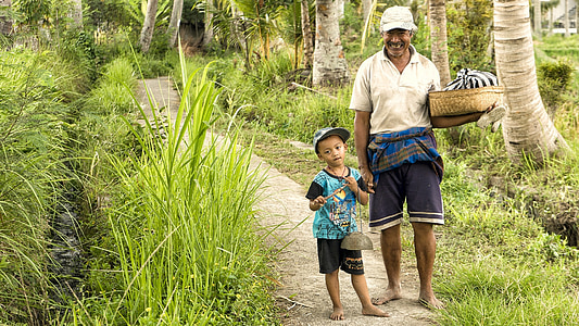 man and boy standing near tree smiling at daytime thumbnail
