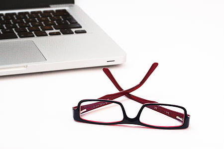 red and black framed eyeglasses beside MAcBook thumbnail