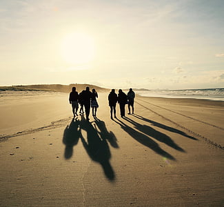 group of people walking on brown sand during daytime thumbnail