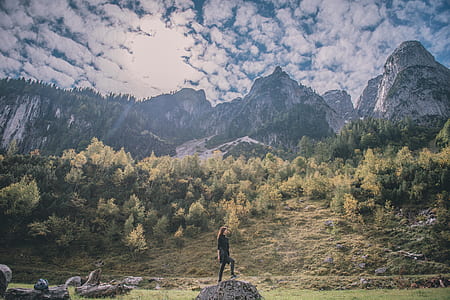 woman standing black rock surrounded by trees thumbnail