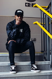 man seating on stairs with hand on his chin thumbnail