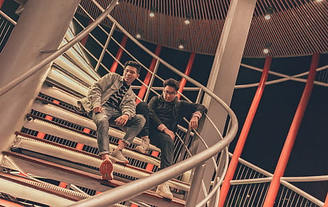 Two Men Sitting on Spiral Stairway thumbnail