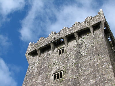 gray concrete building under white clouds and blue sky thumbnail