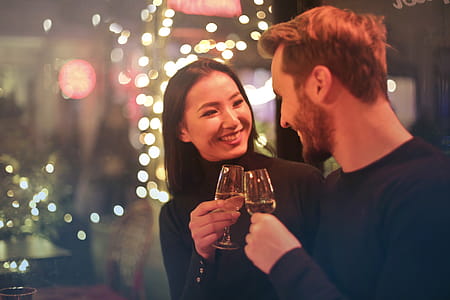 Young couple clanging wine glasses in a bar during a date night out thumbnail