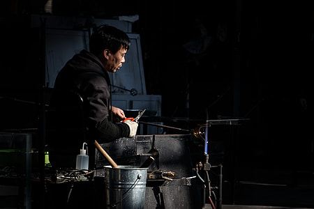 man using scissors beside stainless steel bucket thumbnail