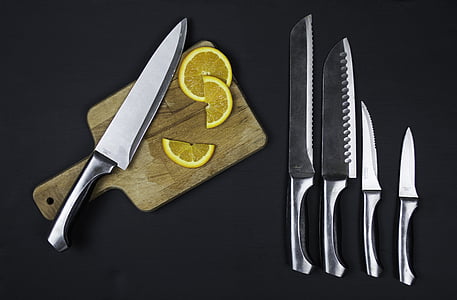 five stainless steel knives and sliced of orange fruit thumbnail
