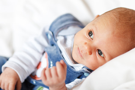 shallow focus photo of baby in blue and white footies thumbnail