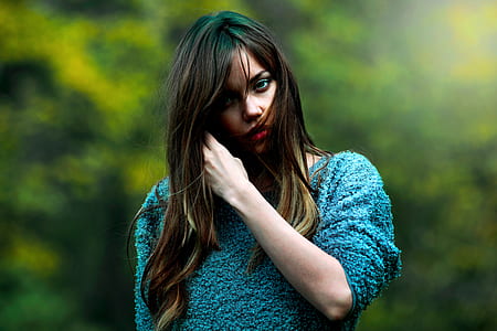 woman fixing her hair while standing outdoors thumbnail