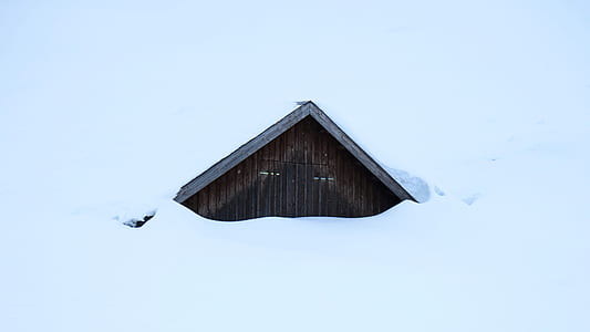 brown house covered in snow thumbnail
