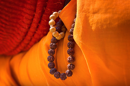 close up photo of brow beaded accessory beside orange textile thumbnail