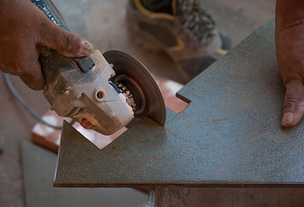 person holding angle grinder cutting tile thumbnail