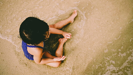 aerial photography of girl sitting on seashore thumbnail