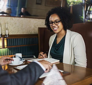 Woman Sitting in Front of Table Looking at Book thumbnail