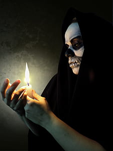 person with skull face paint holding candle thumbnail