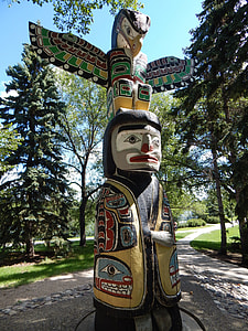 black and multicolored totem near trees at daytime thumbnail