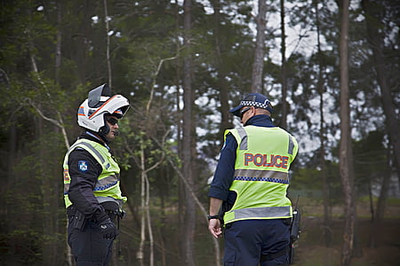 two police officers standing near woods thumbnail