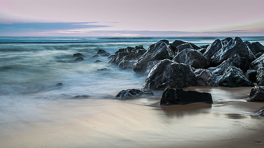 time lapse photography of sea waves crashing on rocks thumbnail