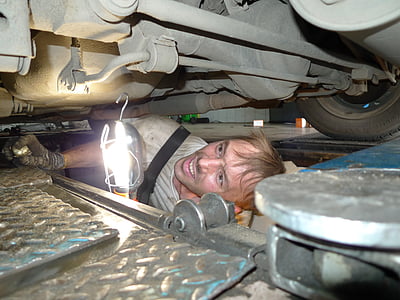 man fixing vehicle under gray vehicle thumbnail
