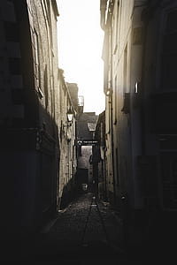 dark narrow pathway between concrete buildings thumbnail