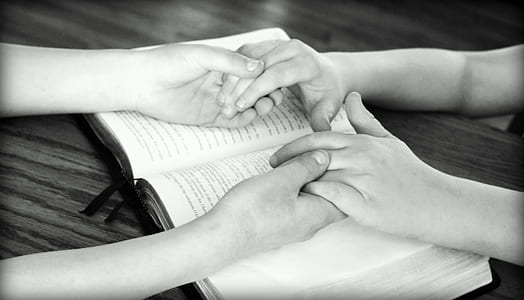 grayscale photography of two person holding hands on book thumbnail