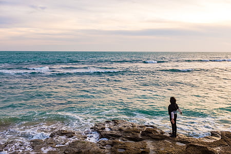 person standing near ocean water thumbnail