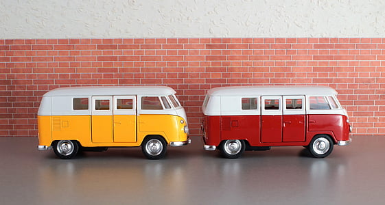 two white, red, and yellow die-cast metal van scale models on gray concrete surface thumbnail