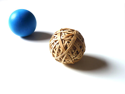 round brown wicker ball and blue ball on white surface thumbnail