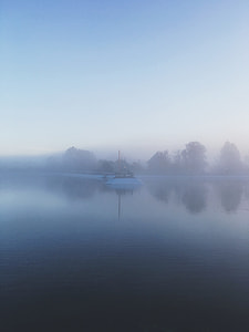 white watercraft on top on body of water with fogs thumbnail