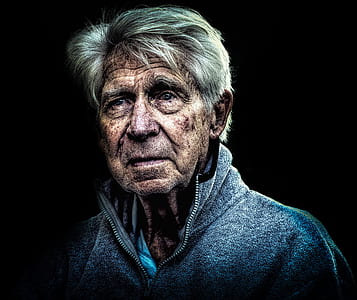 man wearing gray zip-up collared jacket with black background thumbnail