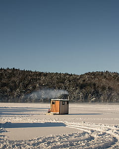 brown wooden storage house in the middle of snow thumbnail