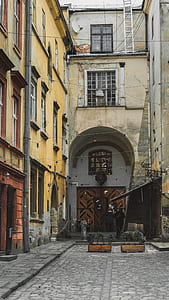 man in black top in front of white building during daytime thumbnail