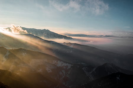 aerial photography of mountain covered with snow under white and blue cloudy skies thumbnail