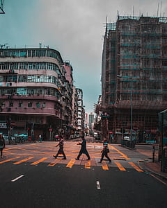 three man crossing on pedestrian lane under gray cloudy skies thumbnail