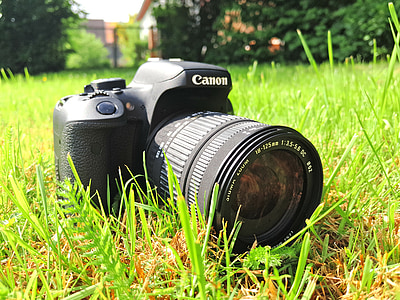 black Canon DSLR camera on lawn thumbnail