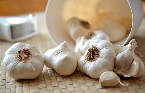 bulbs of garlic on brown woven mat thumbnail