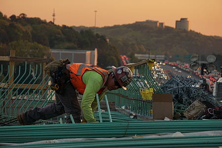 man wearing safety vest walking on roof thumbnail