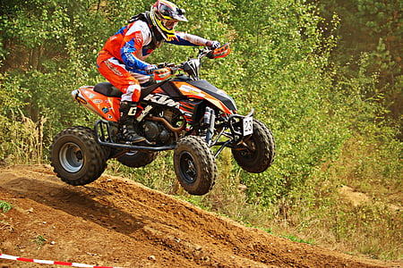 man riding red and black ATV at day time thumbnail