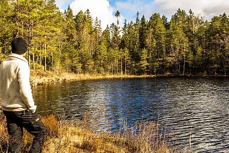 person standing in front of lake during daytime thumbnail