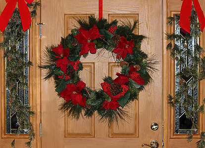 green and black wall wreath mounted on brown wooden panel door thumbnail