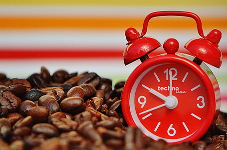 red Techno bell alarm clock on top of coffee beans thumbnail